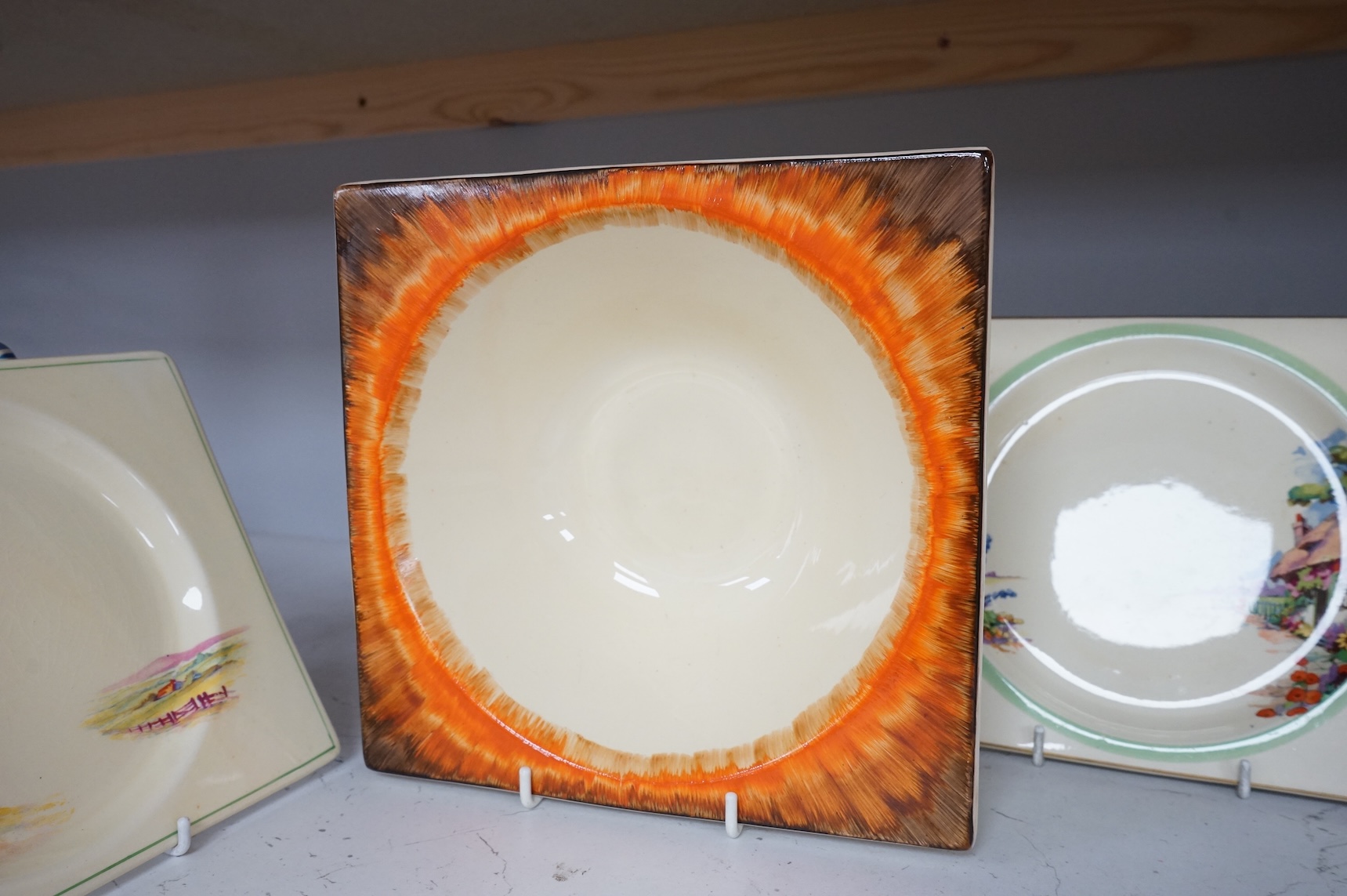 Three Clarice Cliff Bizarre ‘Biarritz’ dishes and a Wilkinson floral jug, largest 23cm wide
